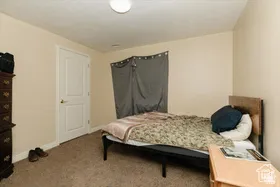 Bedroom featuring light carpet and baseboards