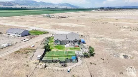 Aerial view of property and surrounding area featuring rural landscape and a mountainous background