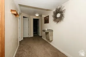 Hall with carpet flooring and baseboards