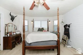 Bedroom featuring multiple windows, light wood-style floors, and ceiling fan