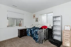Bedroom featuring light carpet and baseboards