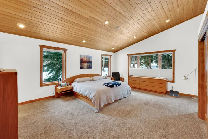 Carpeted bedroom featuring a vaulted wooden ceiling and recessed lighting