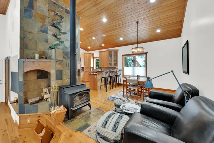 Living room featuring a wood stove, a vaulted wood ceiling, light wood-type flooring, and recessed lighting