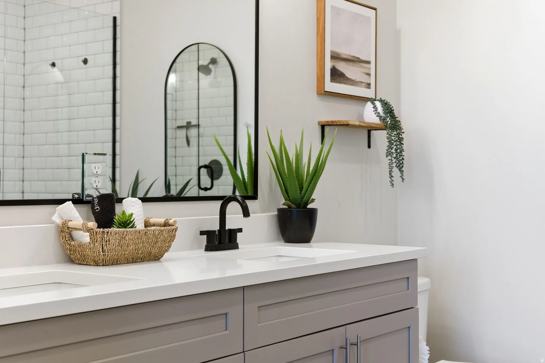 Full bath with double vanity and tiled shower