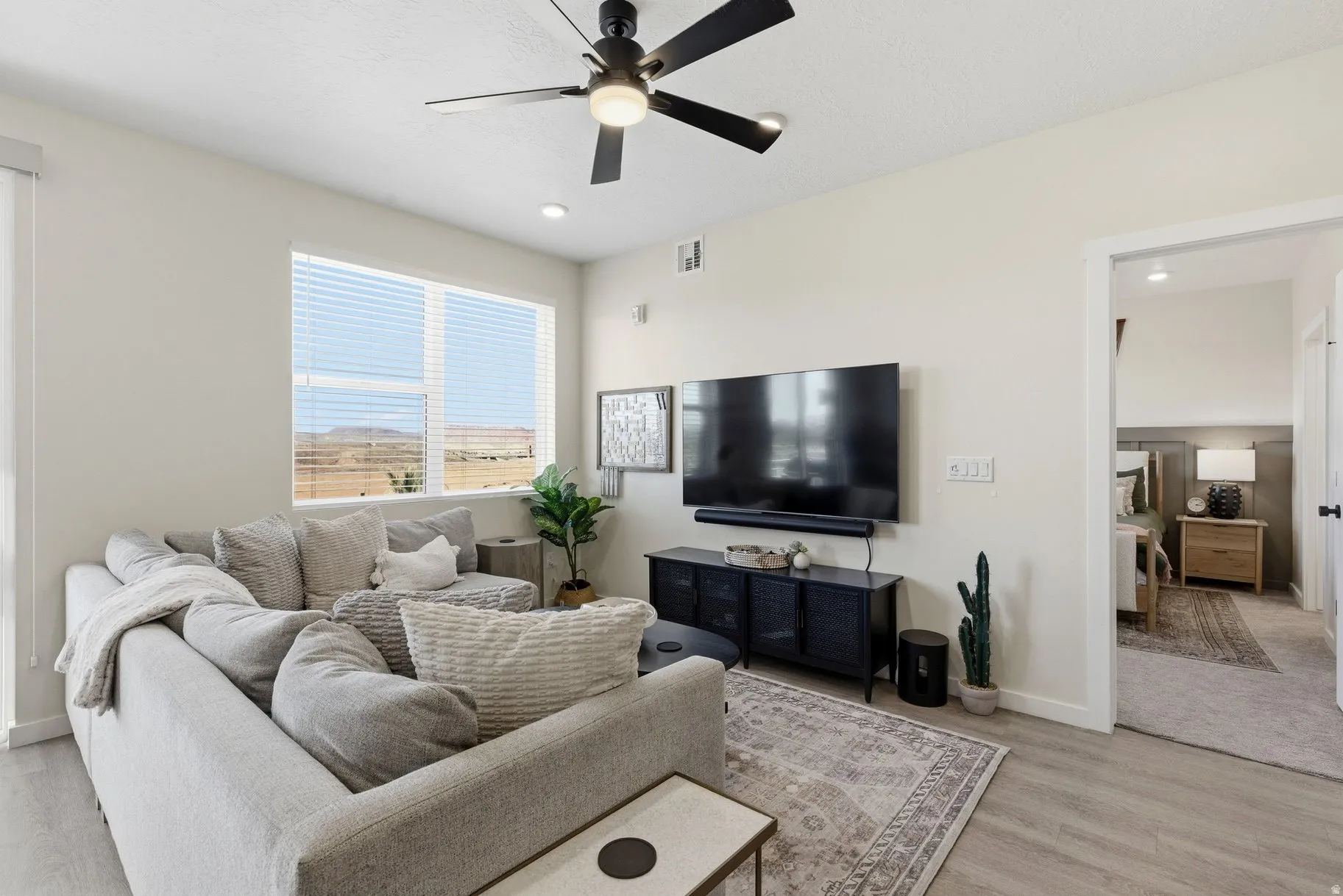 Living area featuring a ceiling fan, light wood-style flooring, and recessed lighting