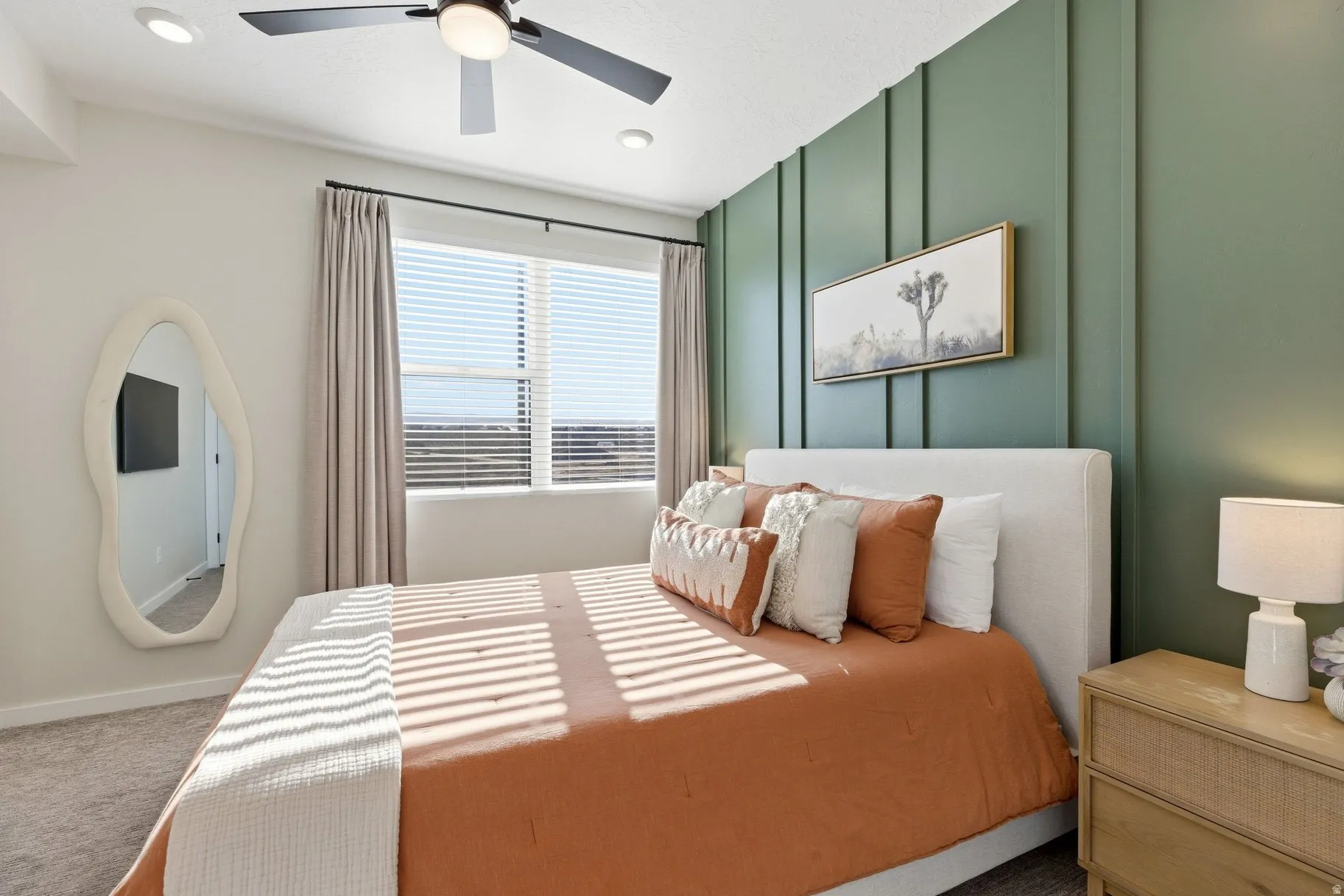Bedroom with carpet floors, ceiling fan, and a decorative wall