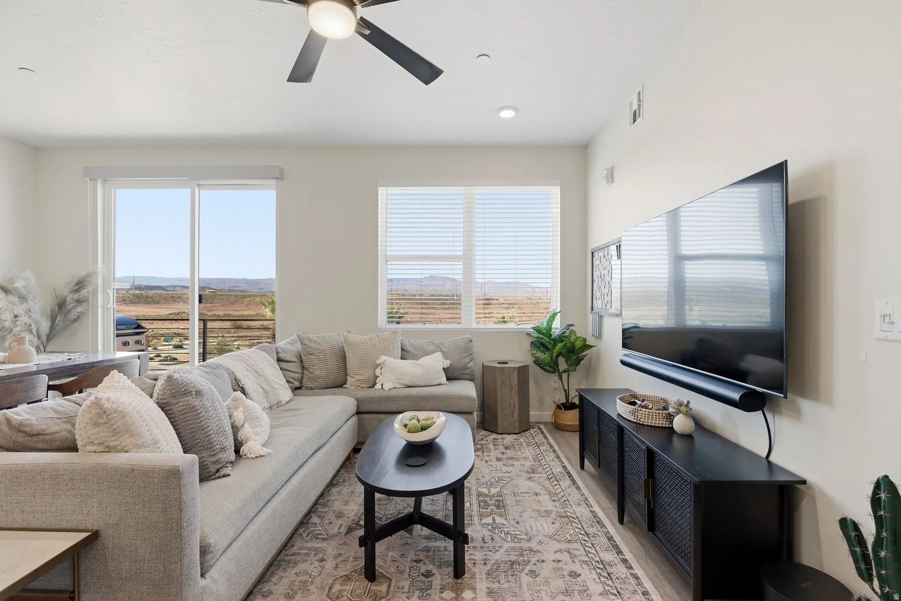 Living room featuring a ceiling fan and light wood-style flooring