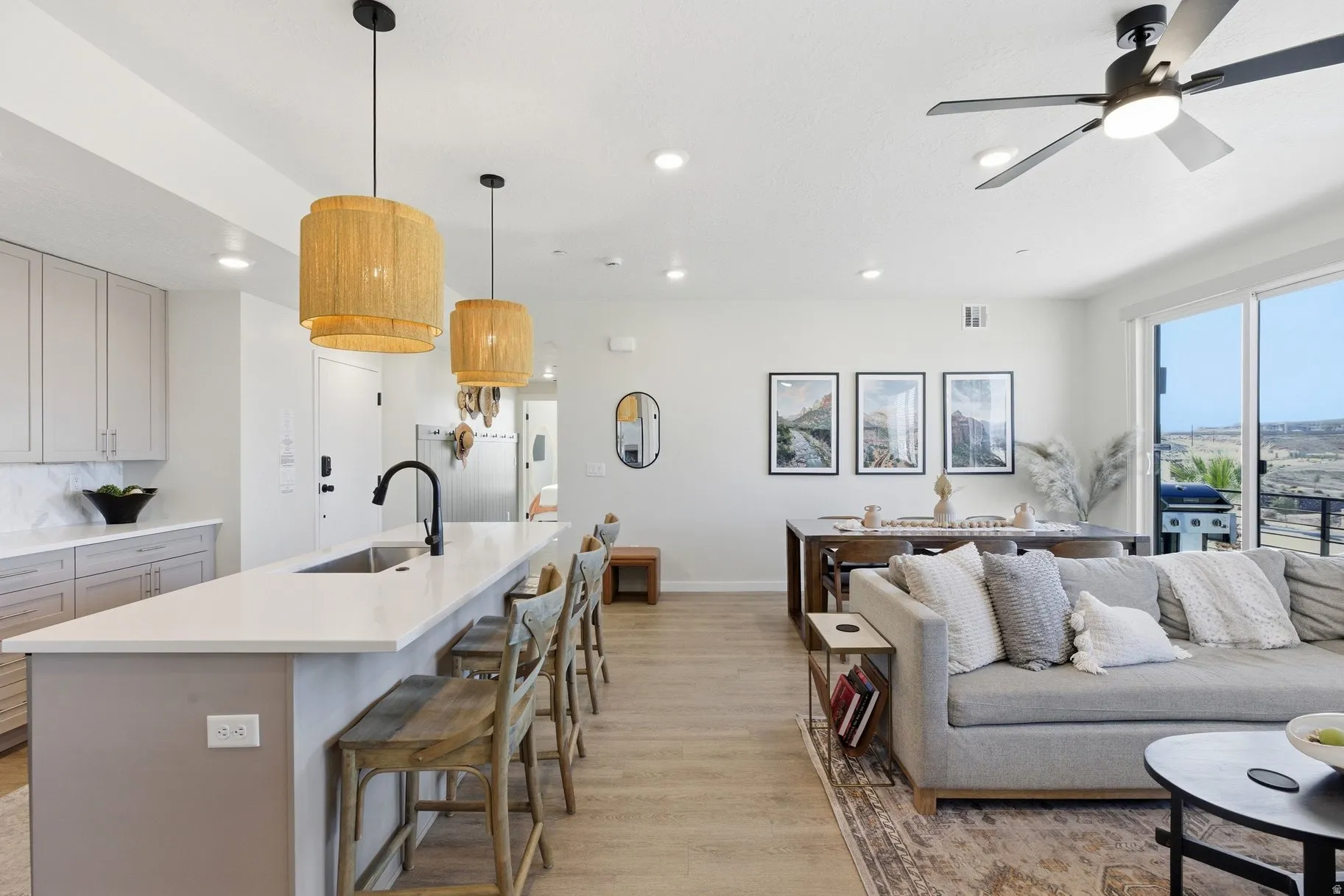Living area with light wood-style floors, ceiling fan, and recessed lighting