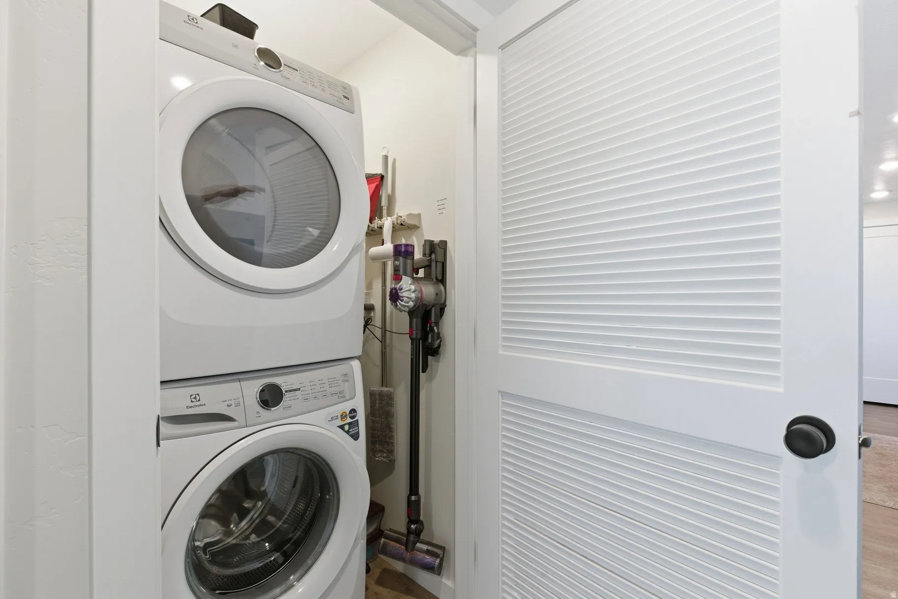 Laundry area with stacked washer and clothes dryer