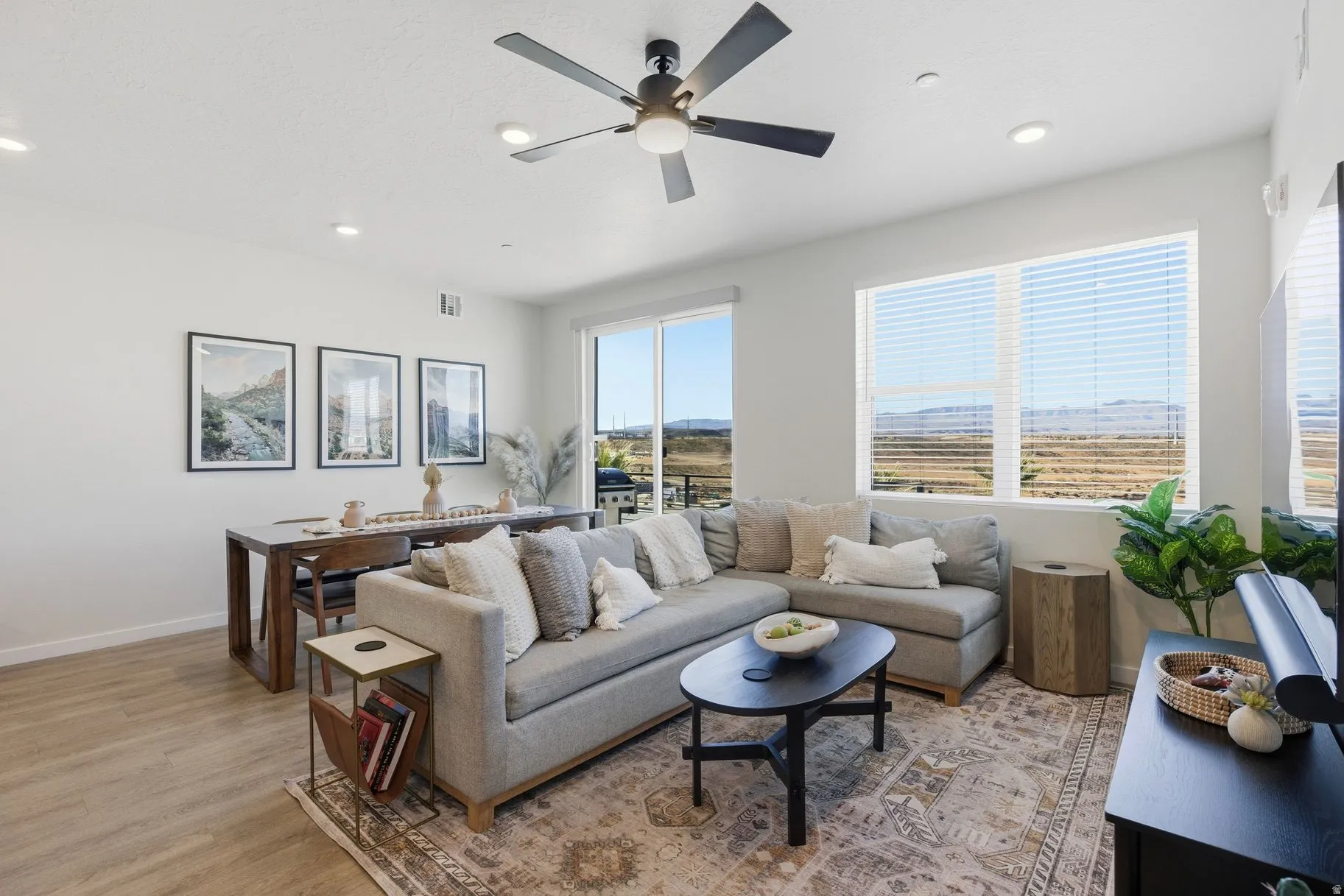 Living room with a ceiling fan, light wood-style flooring, and recessed lighting