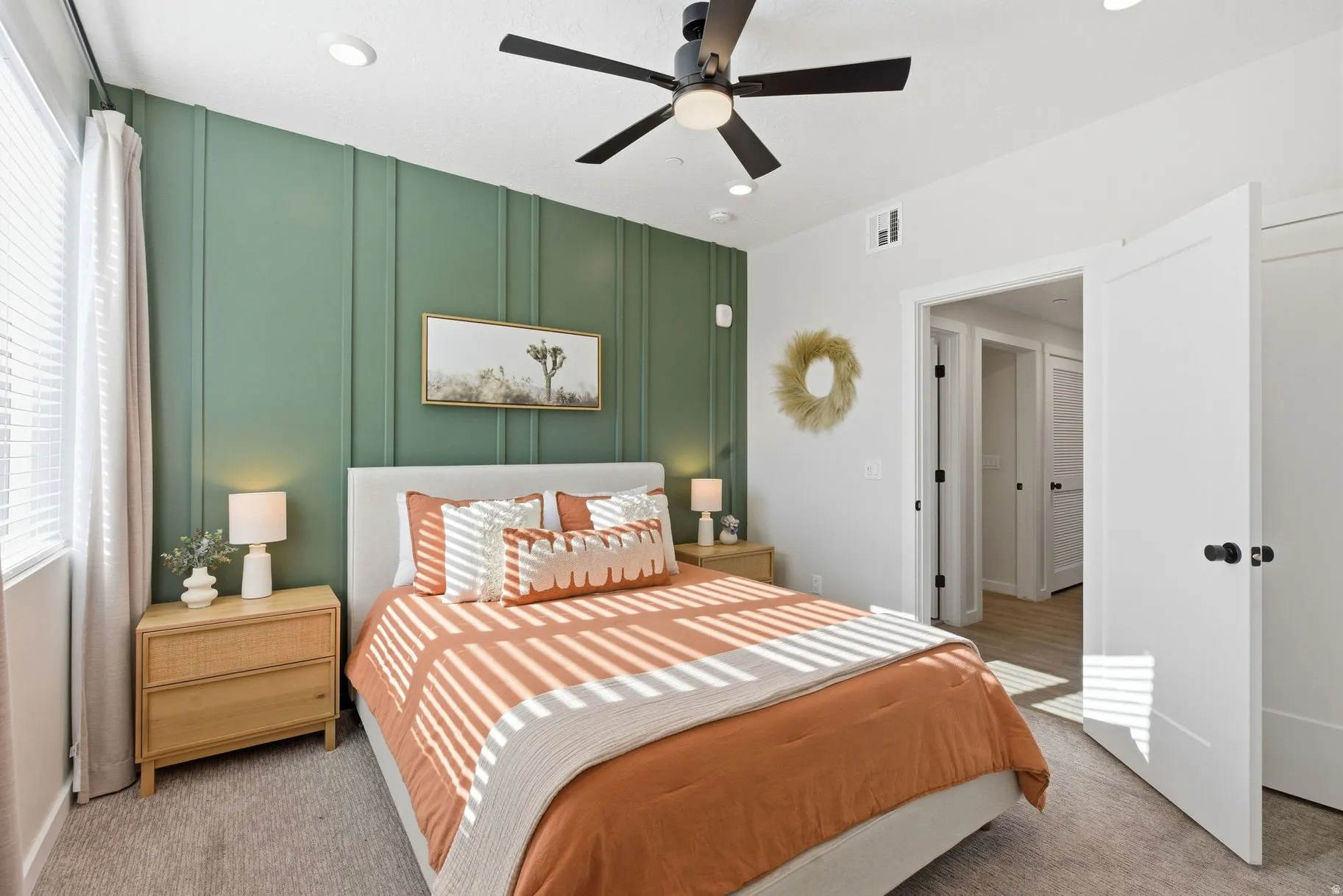 Bedroom with a decorative wall, an accent wall, light colored carpet, a ceiling fan, and recessed lighting