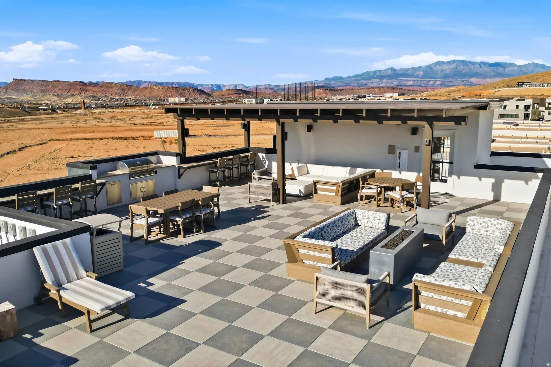 View of patio featuring exterior kitchen, a mountain view, an outdoor bar and dining area, and an outdoor fire pit