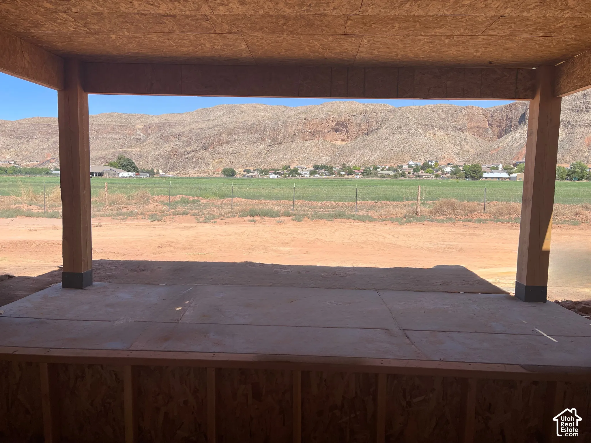 Covered patio with a concrete slab, framed by visible structural wood elements