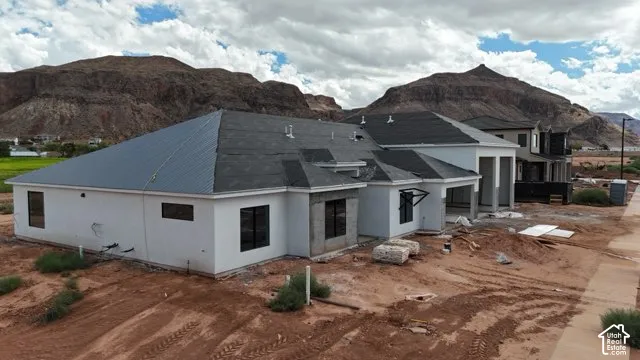 Partially completed construction with white exterior and dark-framed windows