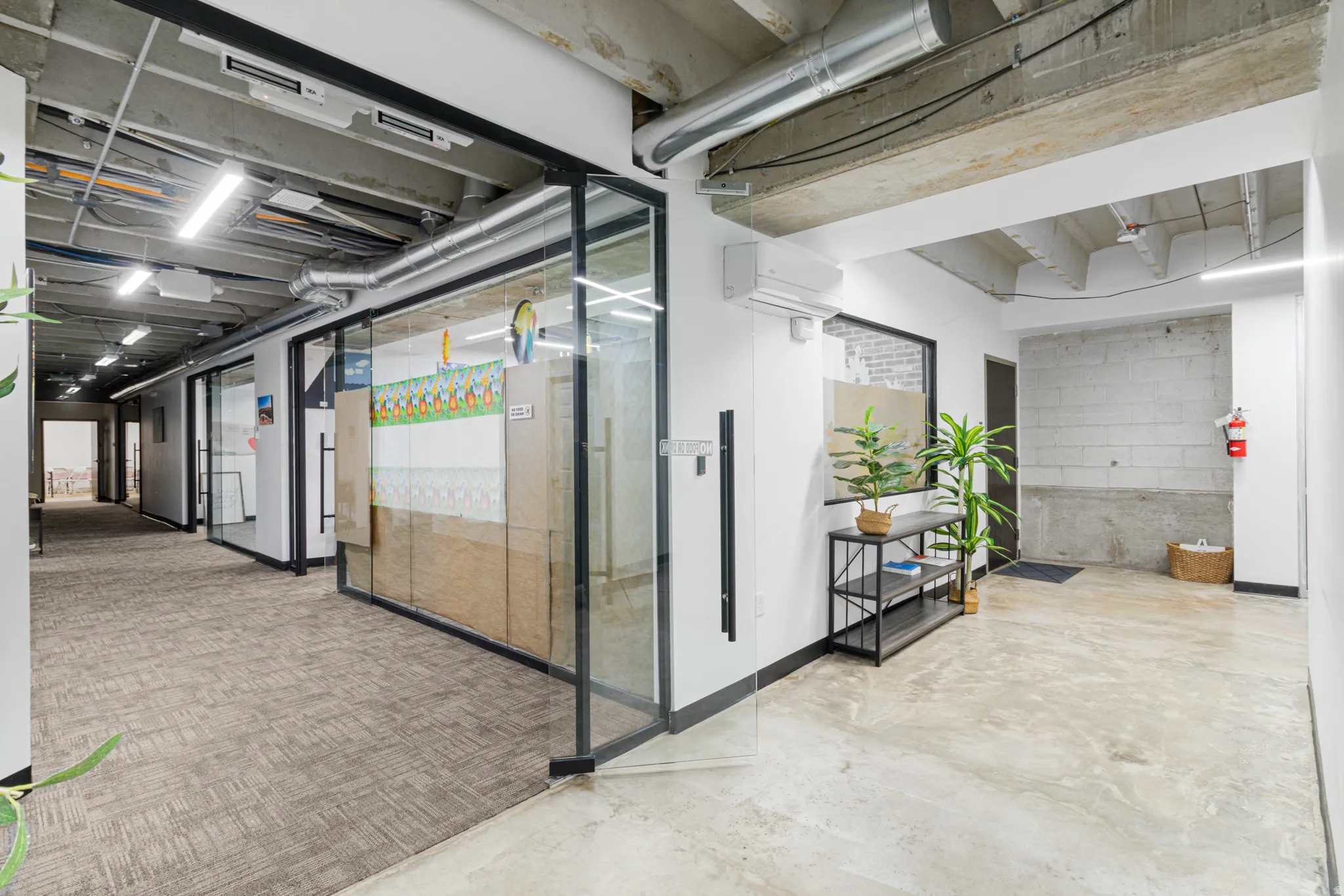 Interior space with concrete floors, a mini split for heating / cooling, and concrete block wall