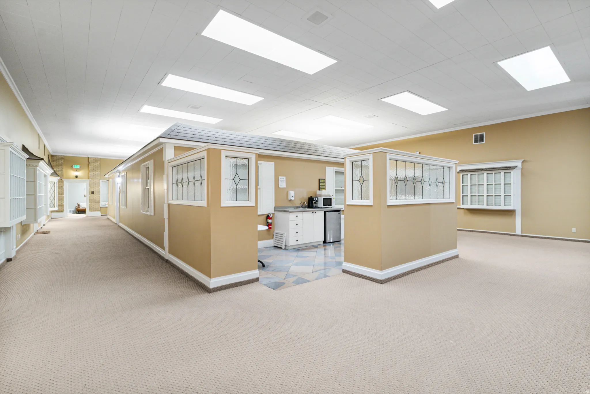 Hallway featuring carpet flooring and crown molding