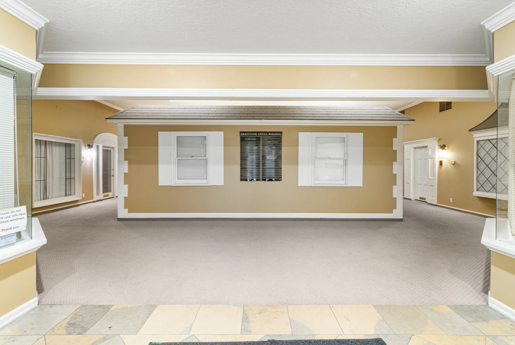 Empty room with light carpet, a textured ceiling, and crown molding