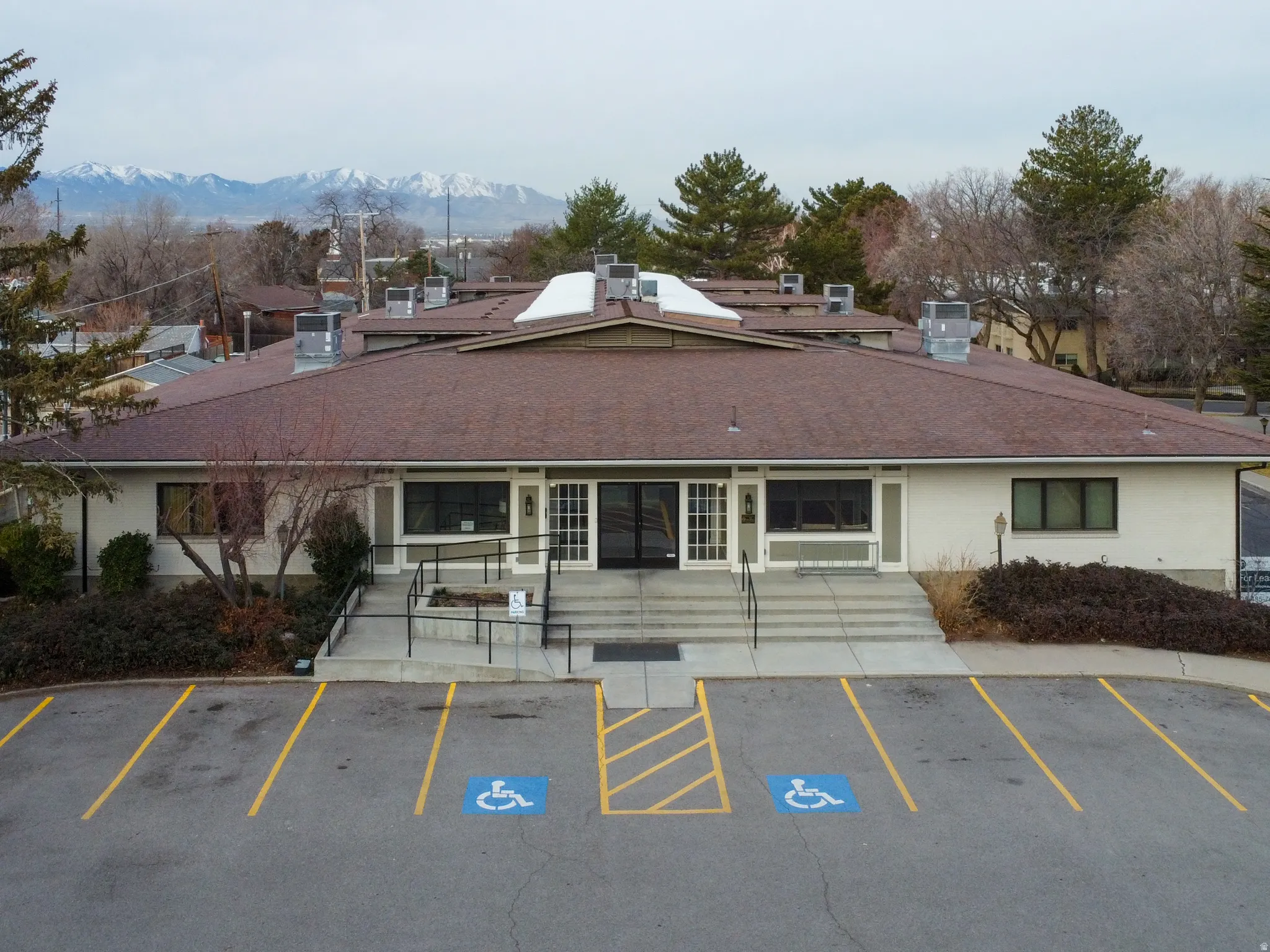 View of building exterior with uncovered parking and a mountain view