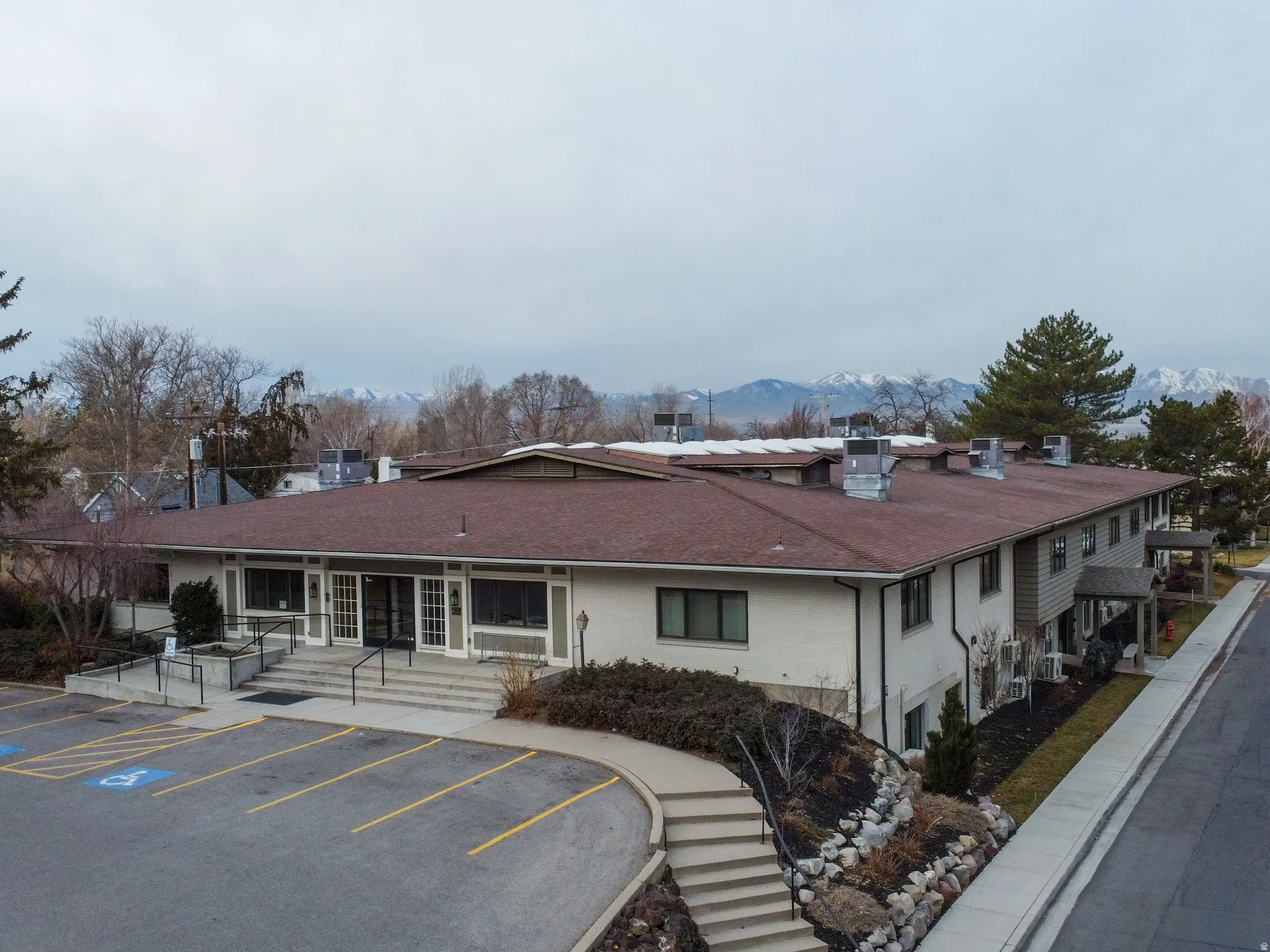View of property with a mountain view and uncovered parking