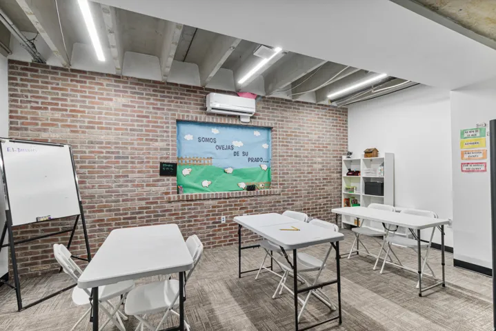Office featuring brick wall and a mini split for heating / cooling