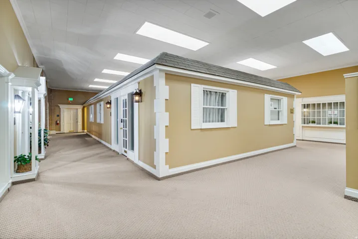 Hallway with carpet floors and baseboards