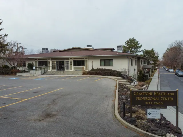 View of building exterior featuring uncovered parking and entry steps