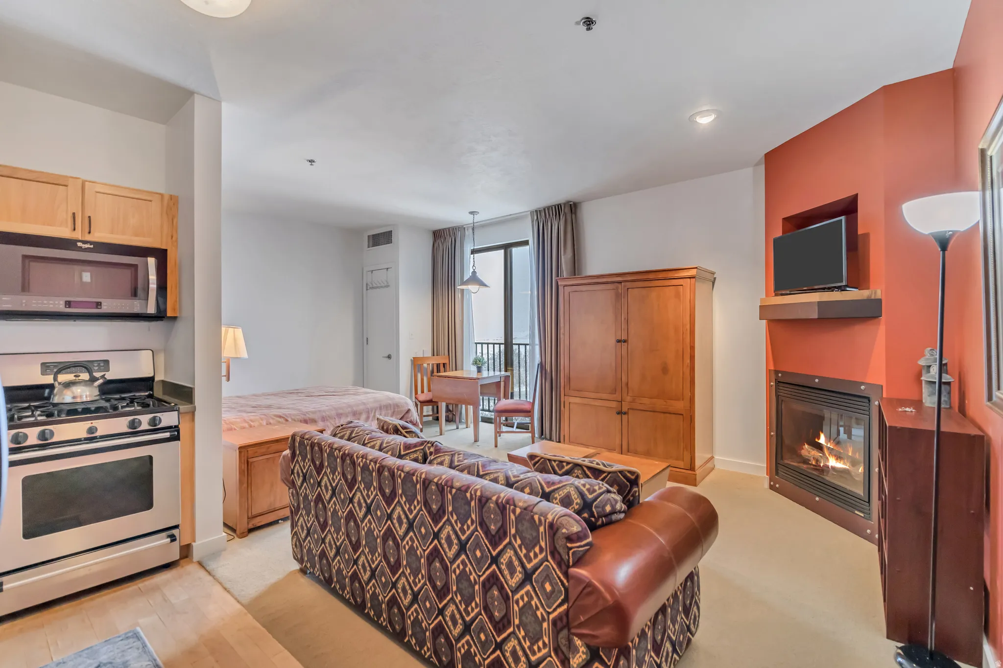 Living area with a glass covered fireplace and baseboards