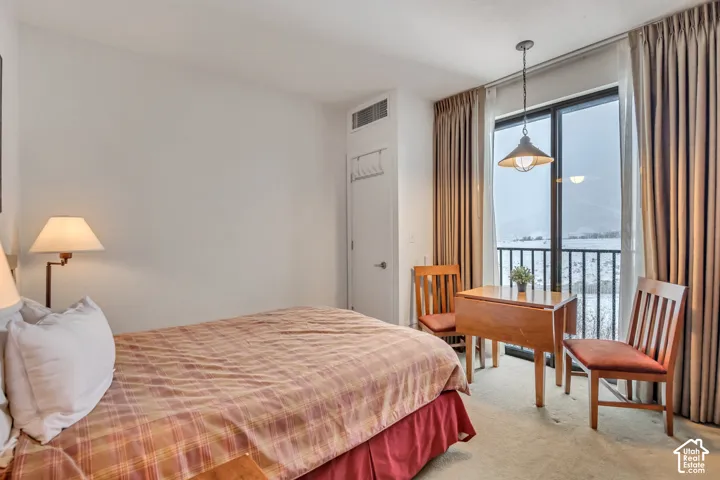 Carpeted bedroom featuring access to outside and a water view
