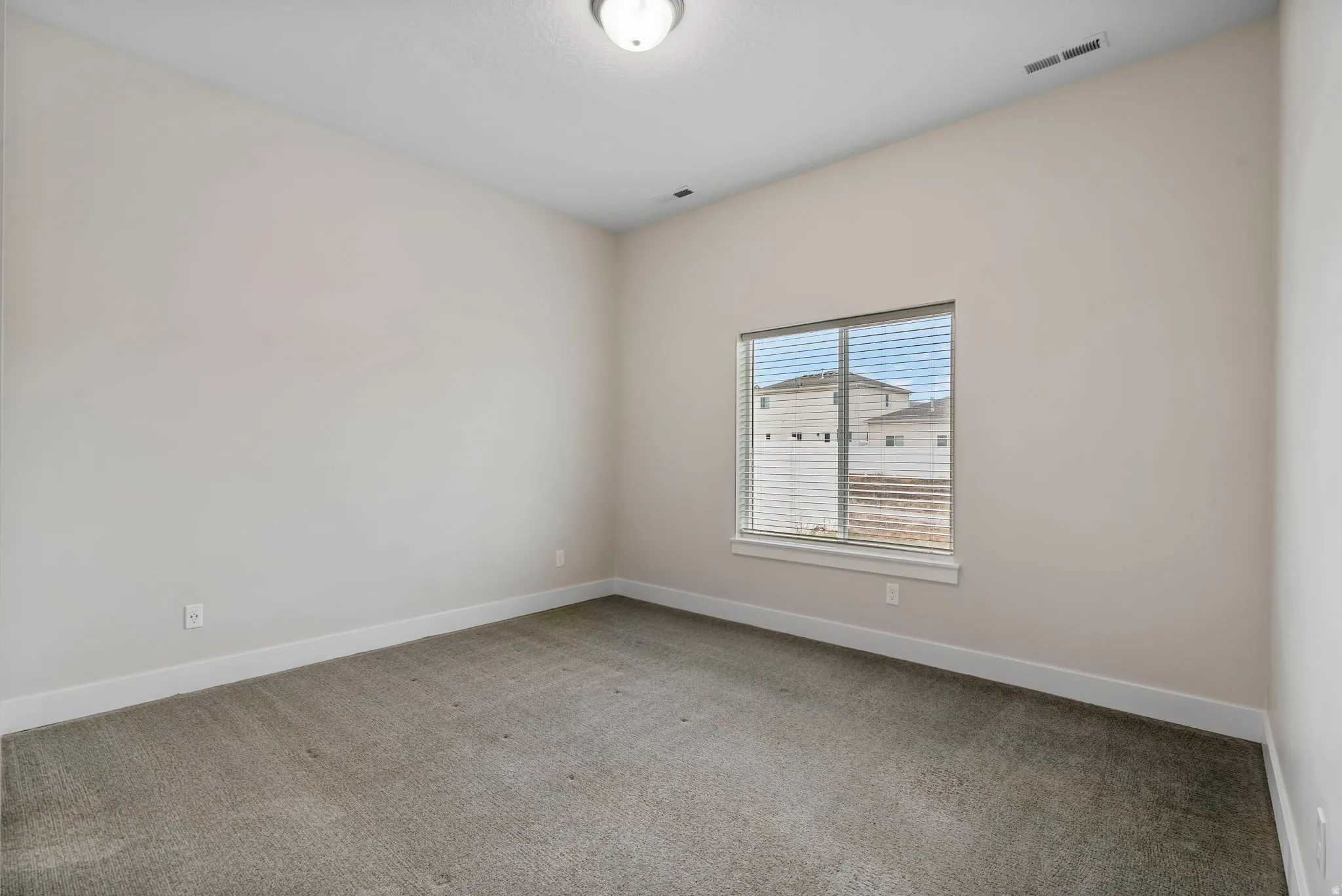 Empty room with carpet flooring and baseboards