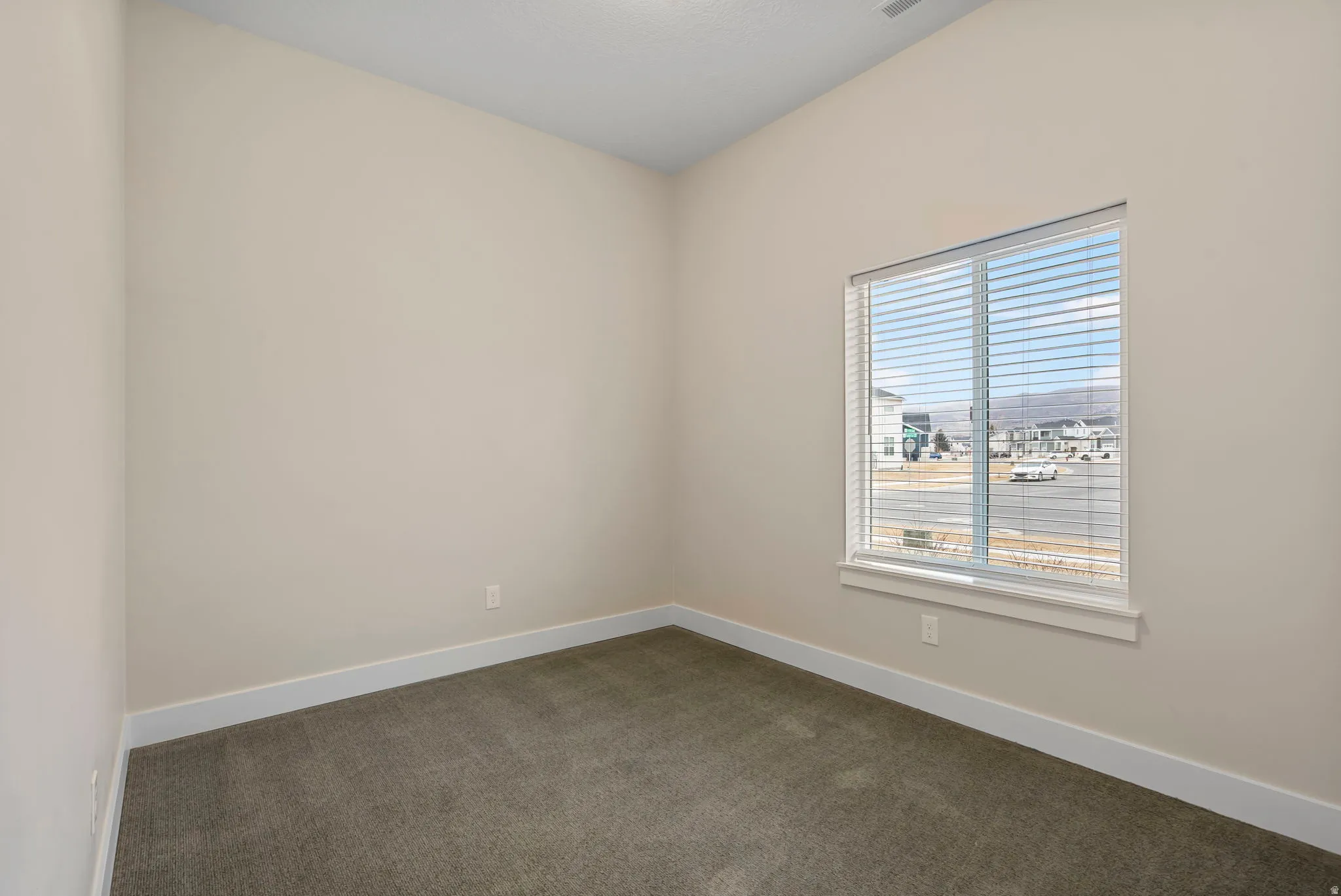 Empty room with dark carpet and baseboards