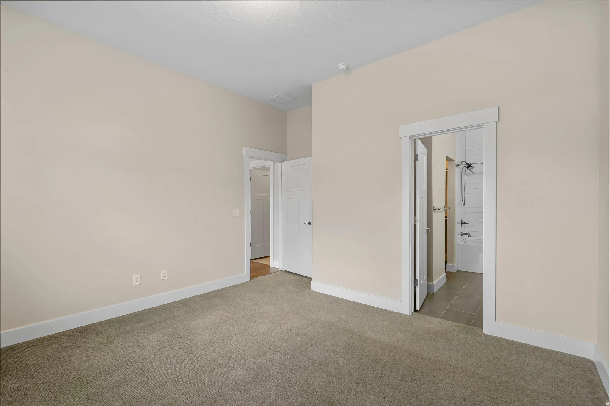 Unfurnished bedroom featuring carpet flooring and connected bathroom