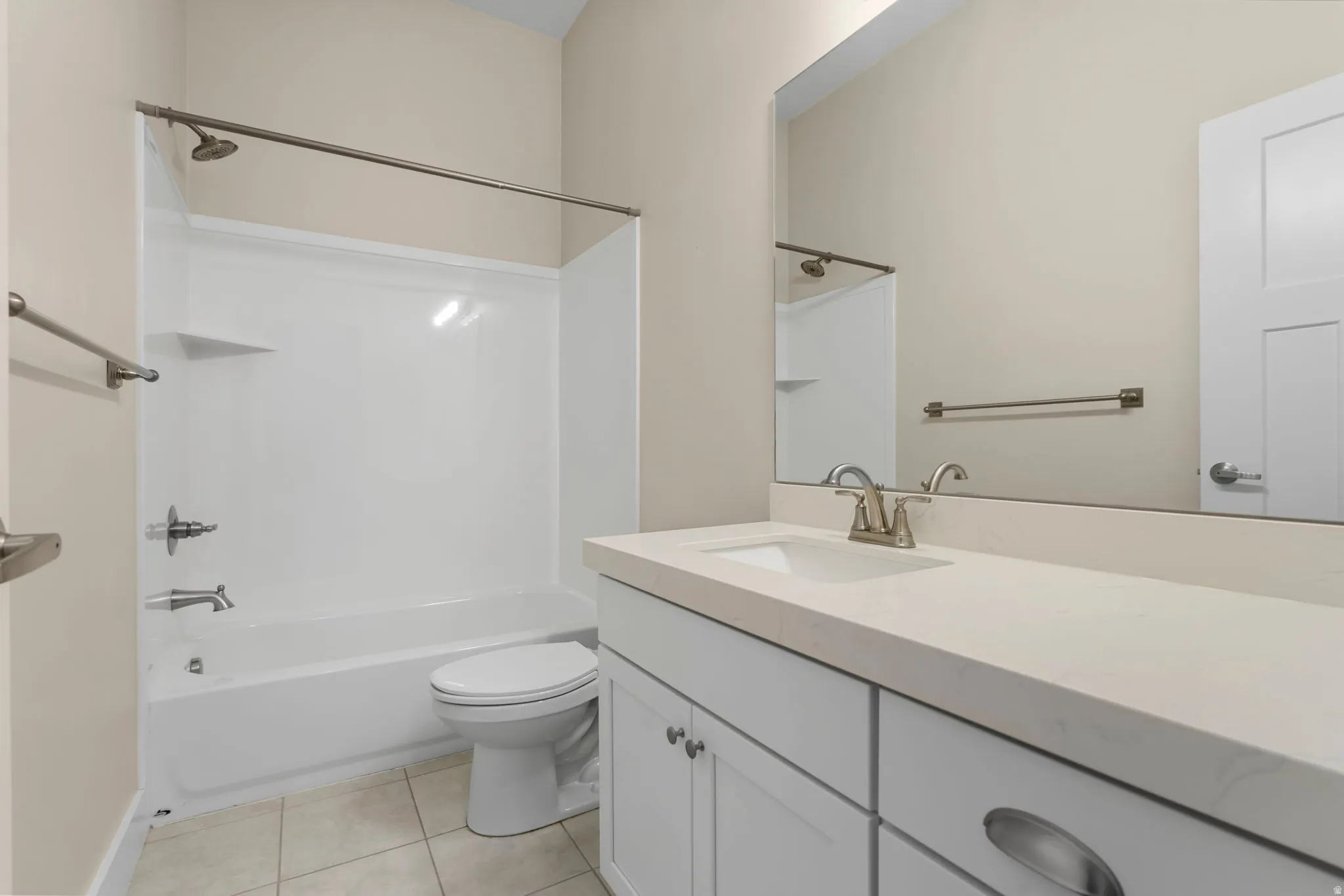 Full bathroom featuring vanity, washtub / shower combination, and light tile patterned flooring