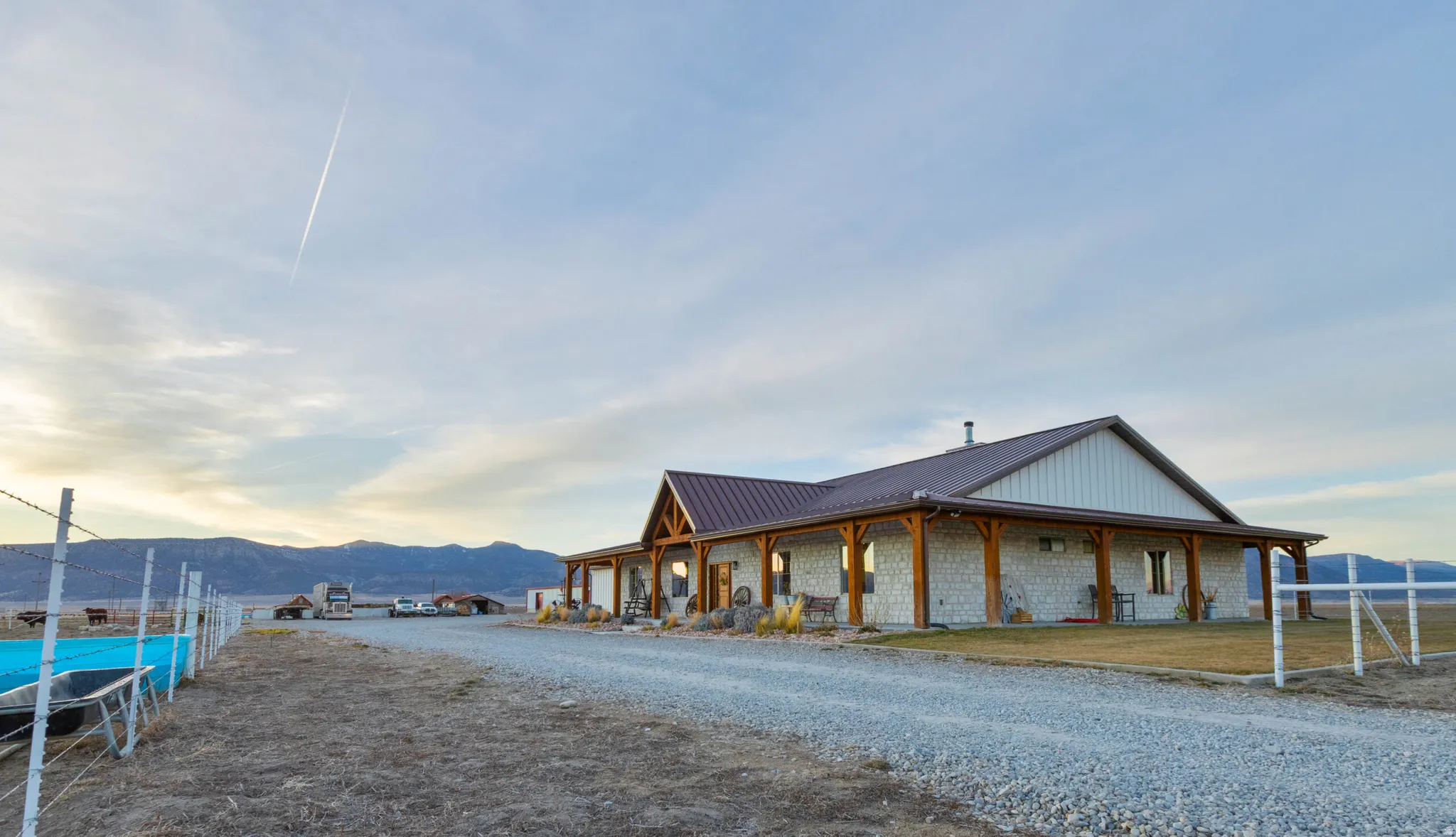 Exterior space with a mountain view, a large porch, a metal roof, and stone siding