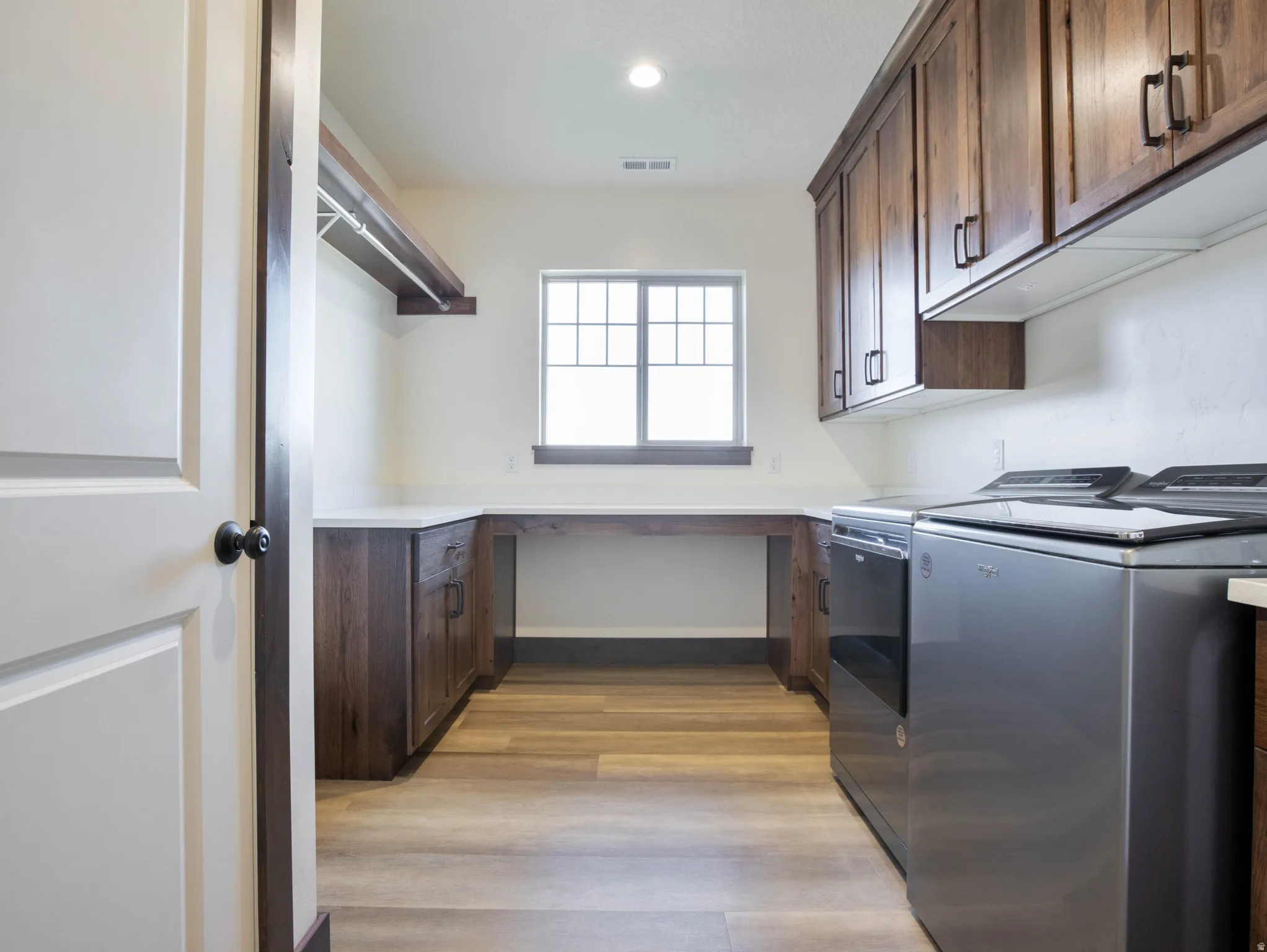Laundry area with separate washer and dryer, light wood-style floors, and recessed lighting
