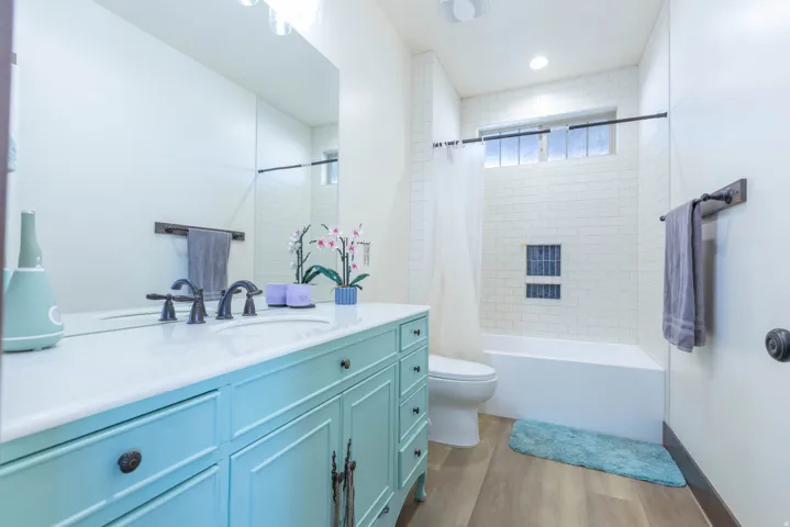 Full bathroom featuring vanity, shower / bath combination with curtain, and light wood-style flooring