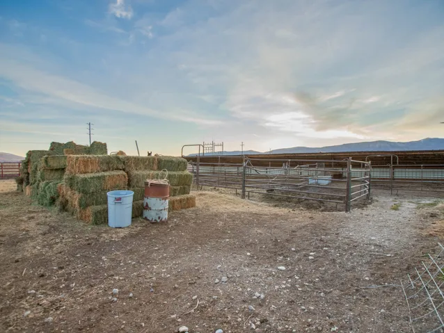 View of yard with a view of rural / pastoral area, an outbuilding, an exterior structure, and a mountain view