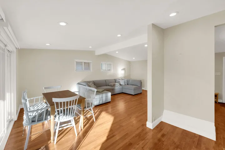 Dining room featuring vaulted ceiling with beams, light wood-style flooring, and recessed lighting