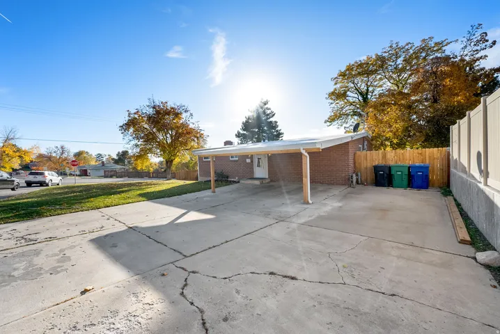 Back of house with brick siding, driveway, and a patio area