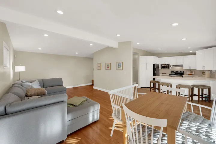 Dining space featuring vaulted ceiling with beams, light wood-style floors, and recessed lighting