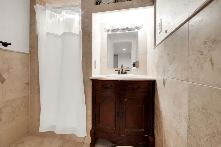 Bathroom with vanity and tile walls
