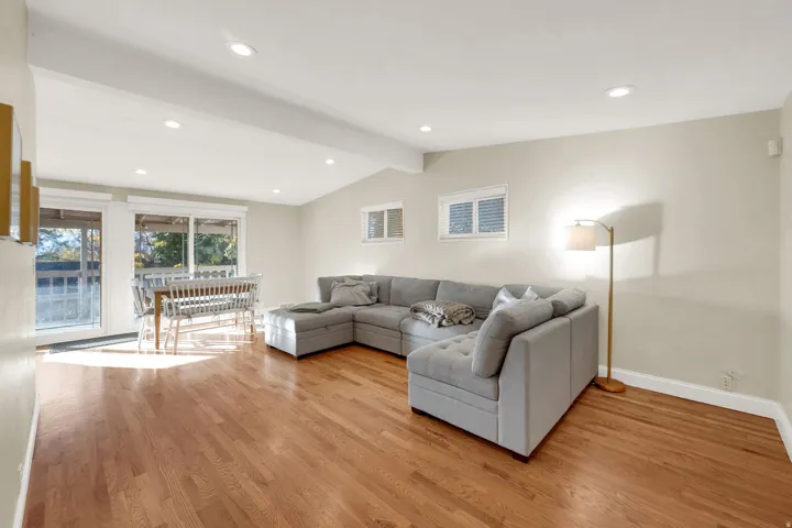 Living room with light wood-type flooring, beamed ceiling, and recessed lighting