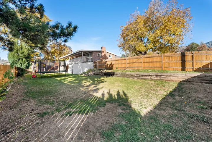 Fenced backyard with a trampoline