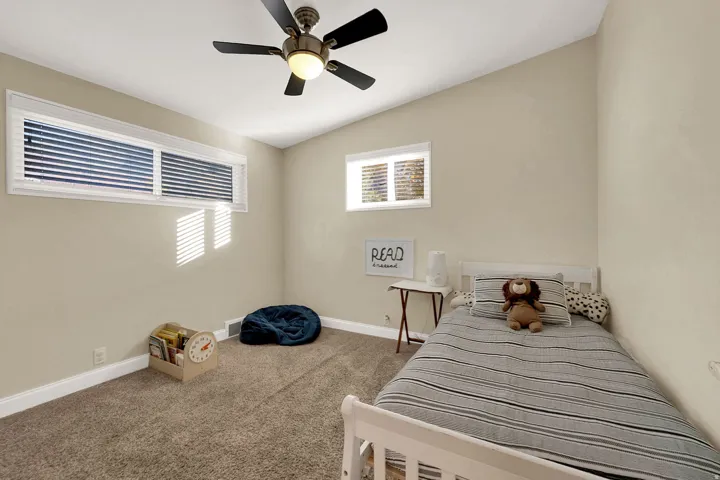 Bedroom featuring ceiling fan, carpet floors, and vaulted ceiling