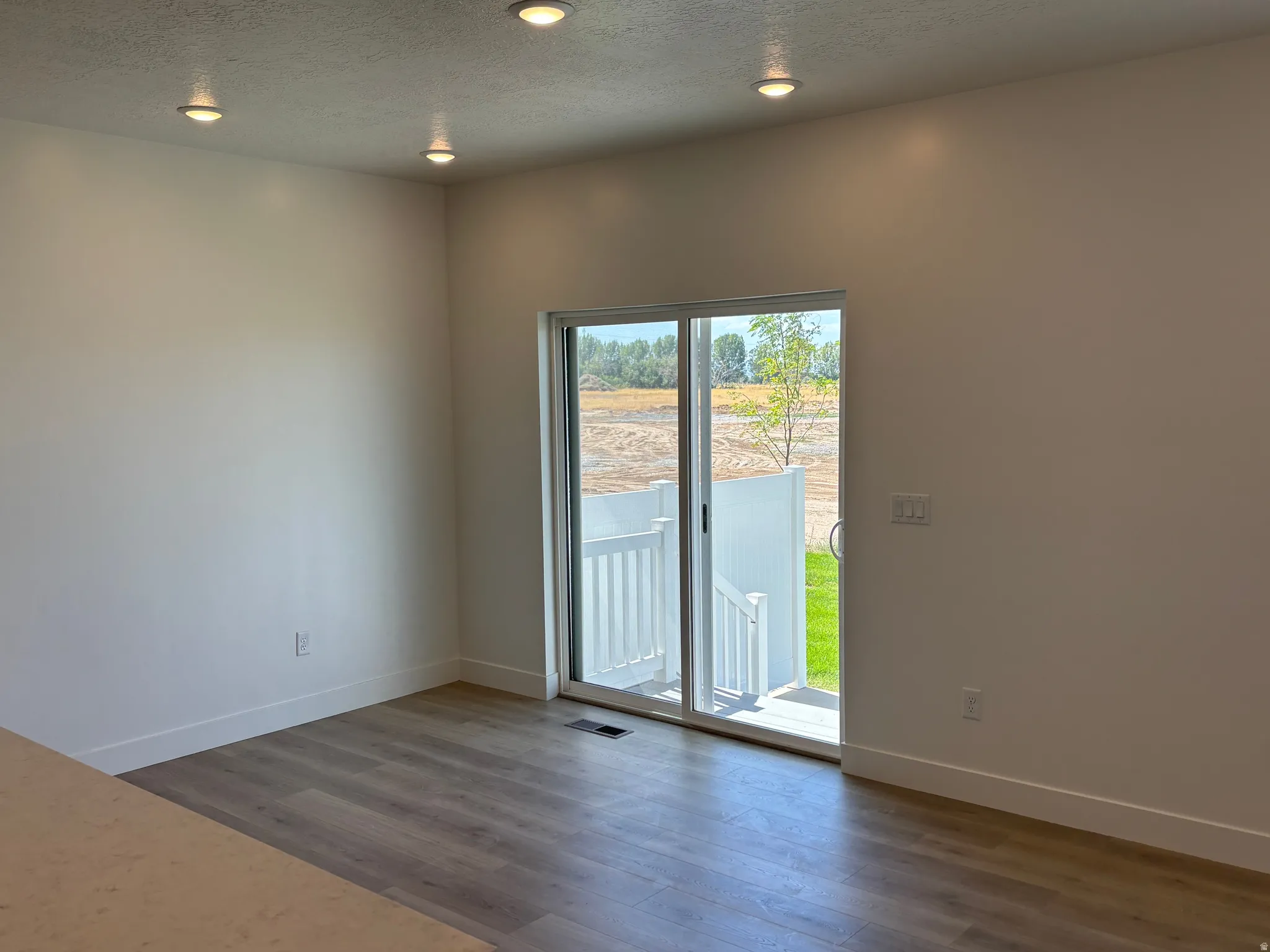 Spare room with a textured ceiling, dark wood-type flooring, and recessed lighting
