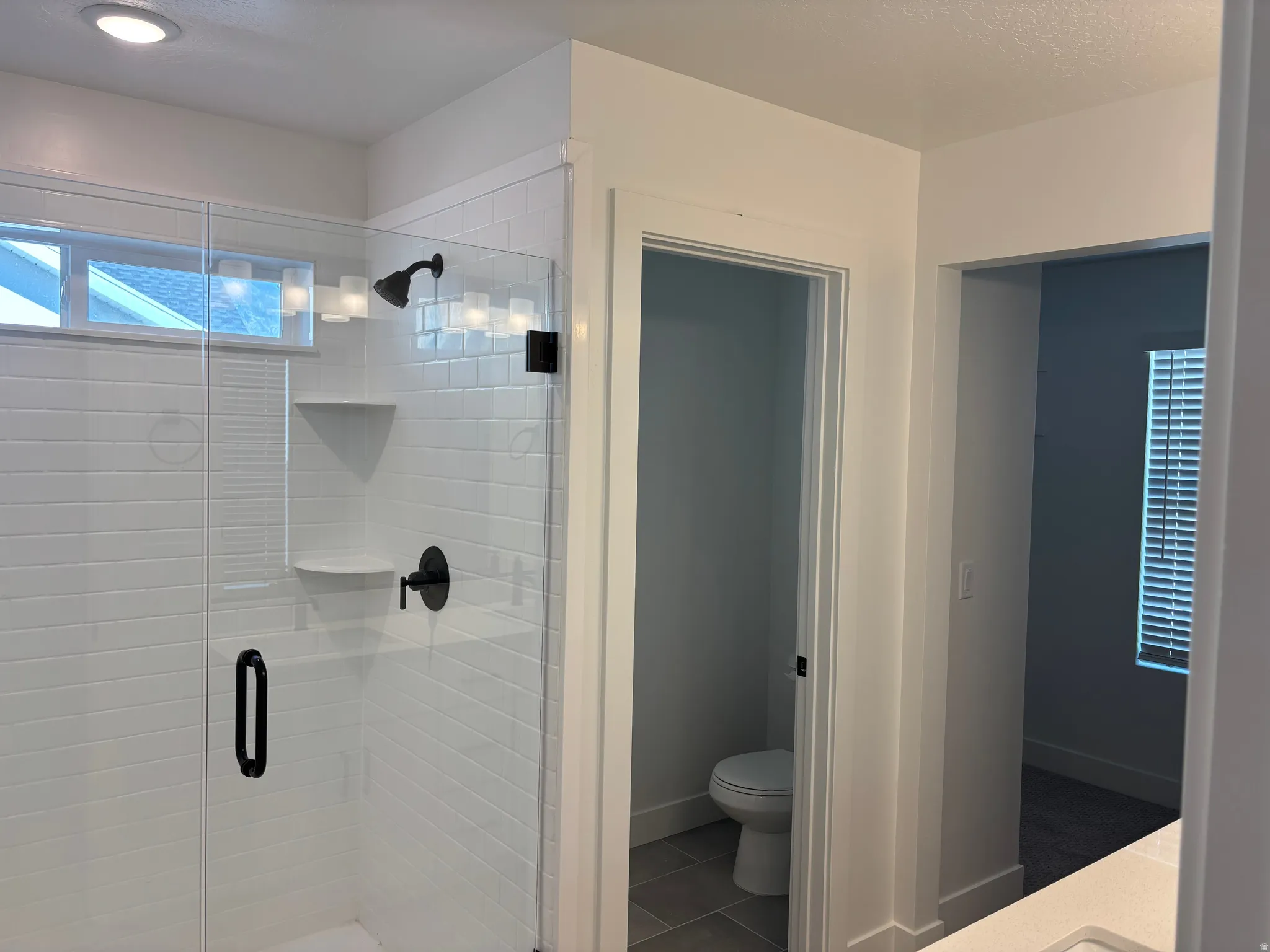 Bathroom with a shower stall, vanity, tile patterned floors, and a textured ceiling