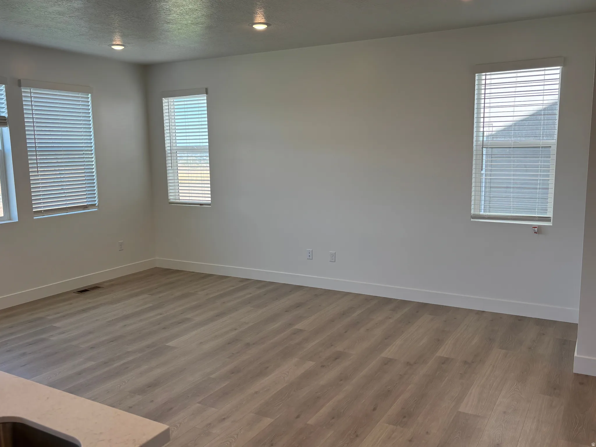 Unfurnished room featuring light wood-style flooring and a textured ceiling