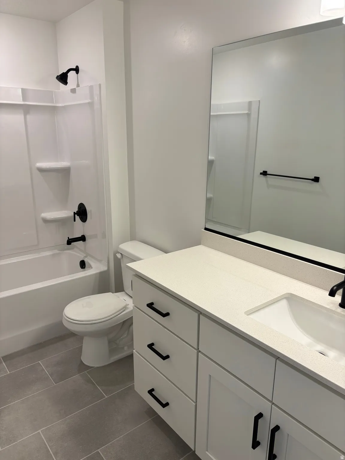 Full bath with vanity, shower / bath combination, and dark tile patterned flooring