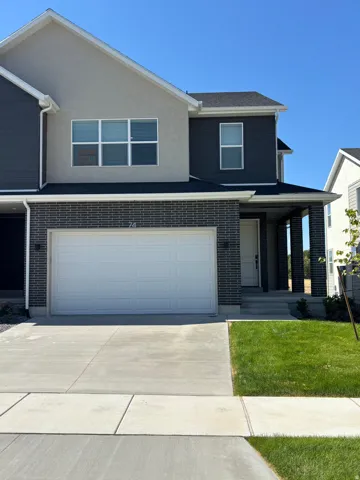 View of front of property featuring a porch, an attached garage, concrete driveway, a front yard, and stucco siding