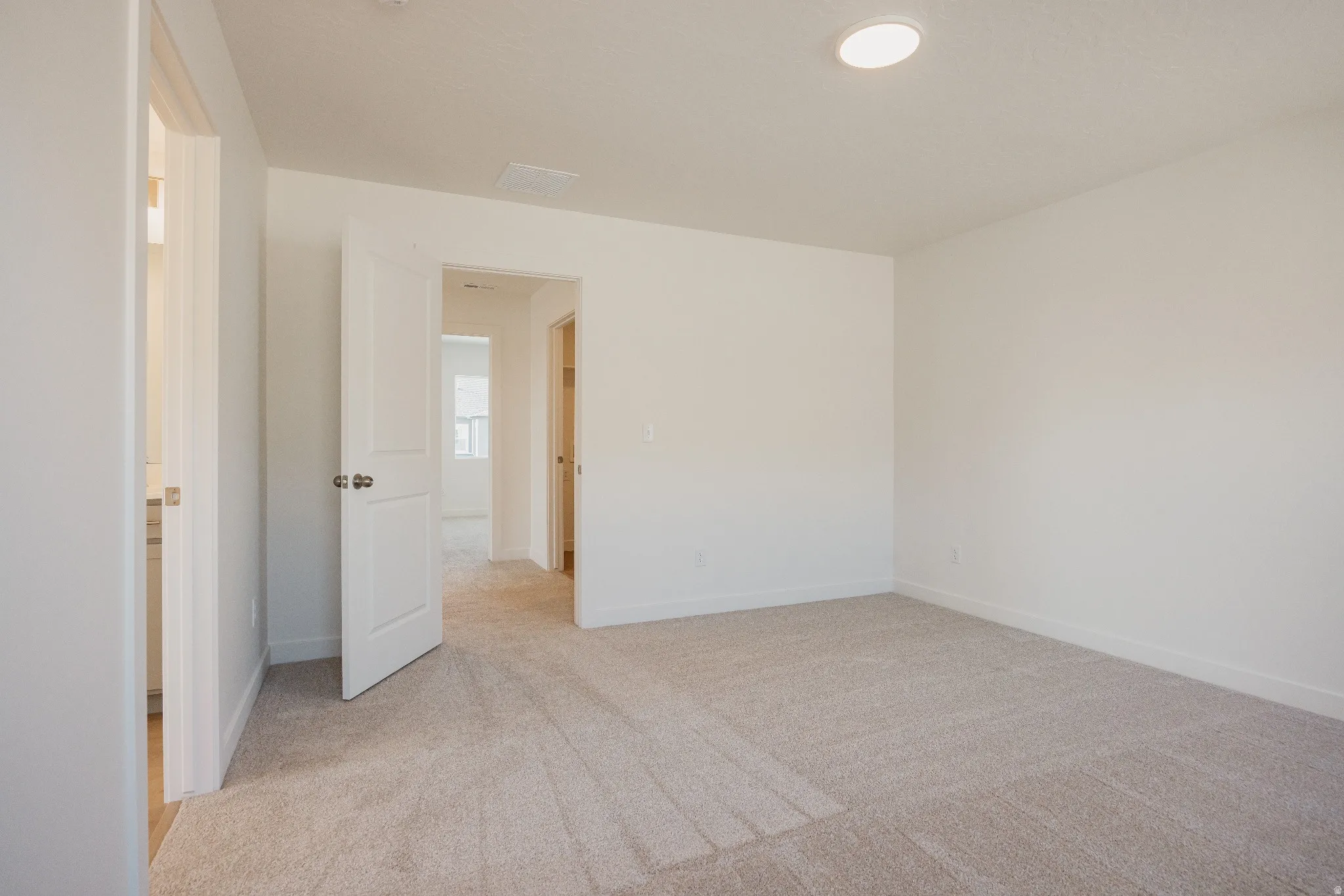 Empty room featuring light carpet and baseboards