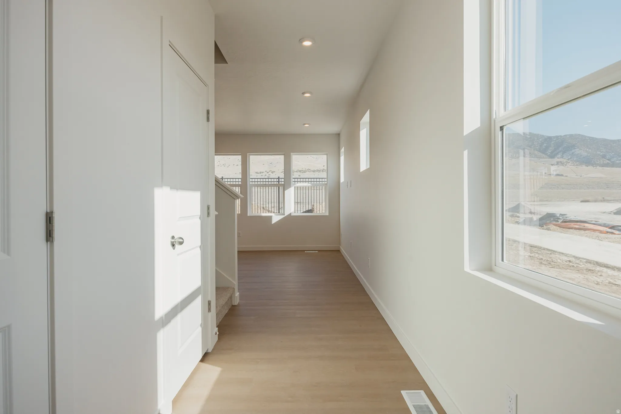 Hall featuring light wood finished floors and recessed lighting